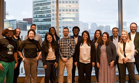 AHEM attendees in front of a window and the Boston skyline