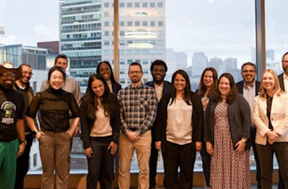 AHEM attendees in front of a window and the Boston skyline